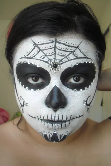 Halloween skeleton face paint reference with black eye sockets and nose shading
